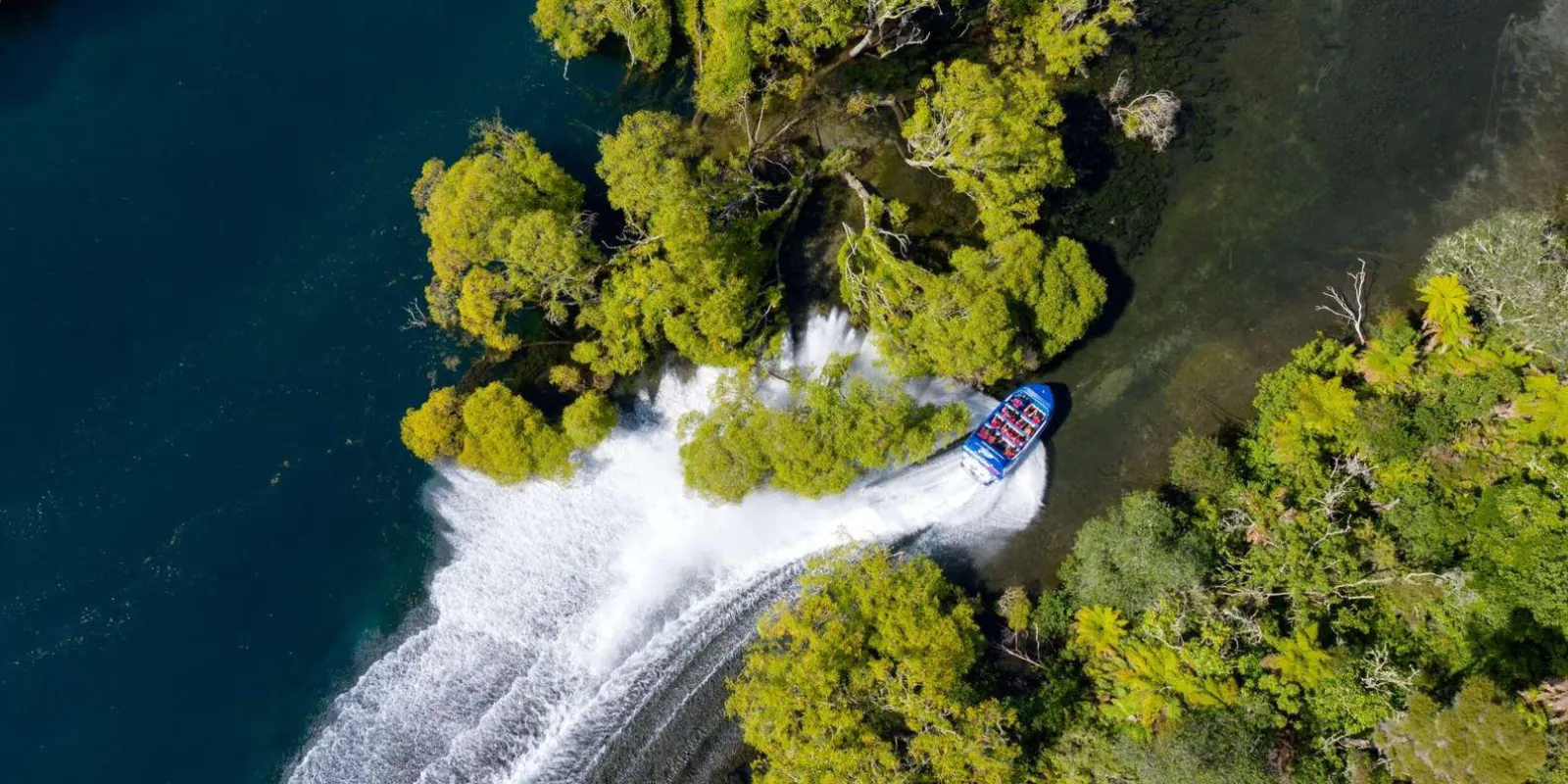 Aerial view of a jet boat leaving a curved wake on the Waikato