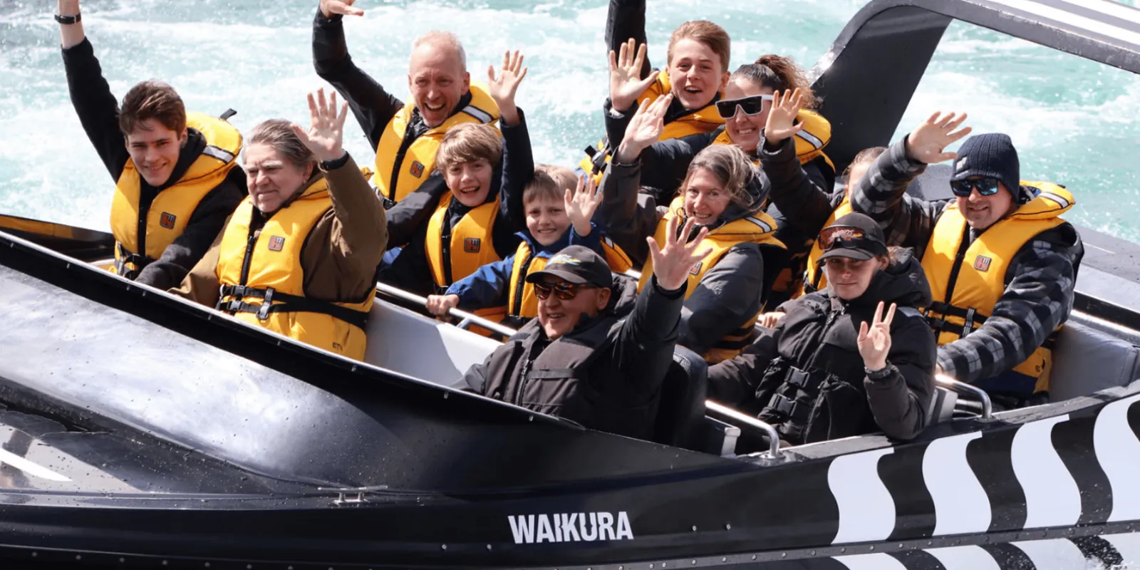 Passengers aboard the black Waikura Rapids Jet boat