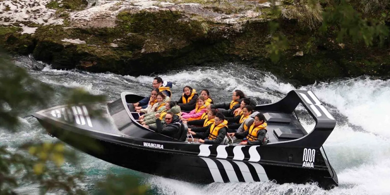 Rapids Jet boat passing a rocky riverbank
