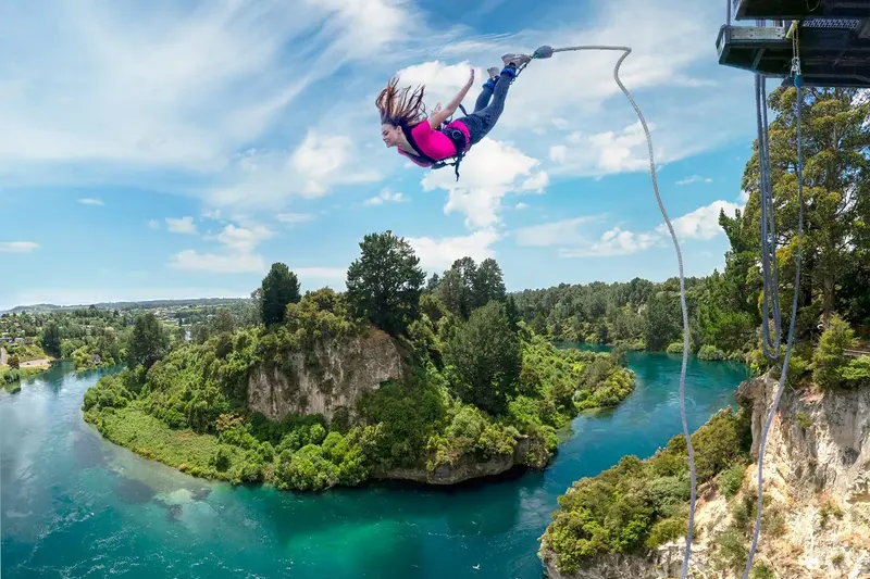 Bungy jumper leaving the cliff-top platform above the Waikato River