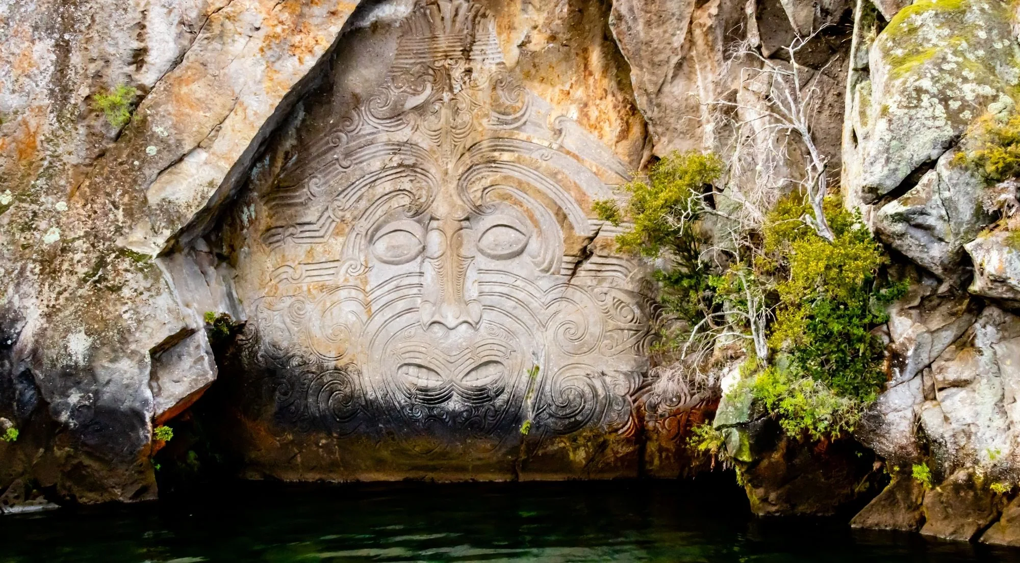 Māori rock carving on the cliffs at Mine Bay